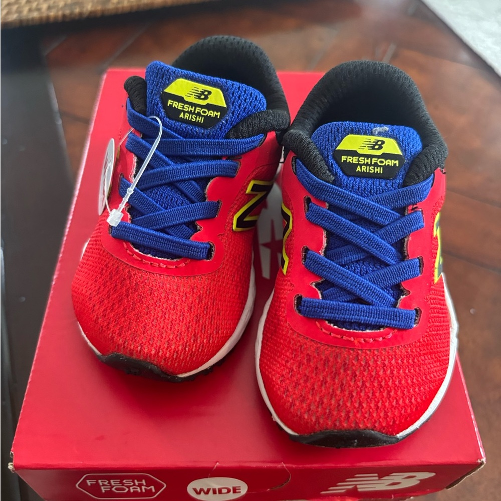 New Balance Kids Sneakers in Vibrant Red with Blue and Yellow Highlights